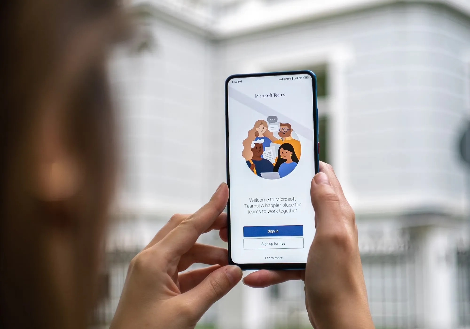 Woman holding phone up with Teams on